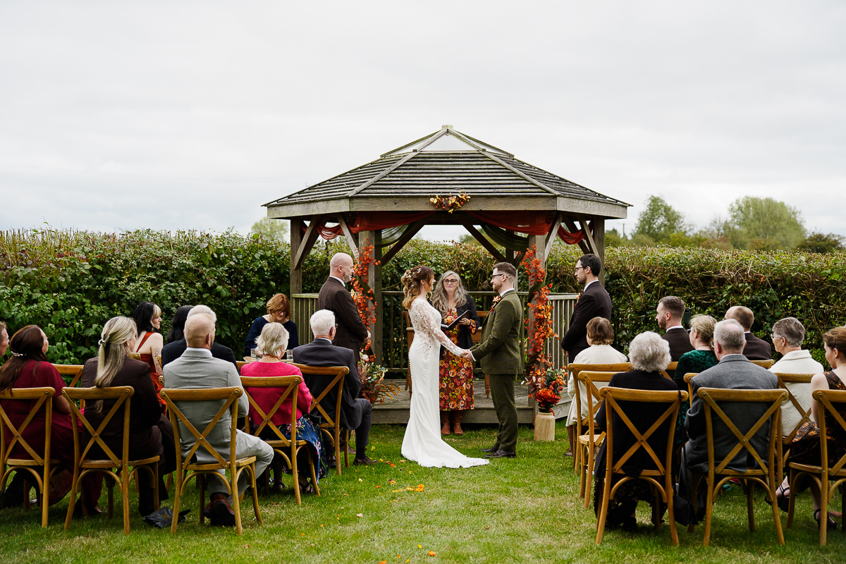 Intimate outdoor micro wedding ceremony under the licensed wooden pagoda at Pennard Hill Farm